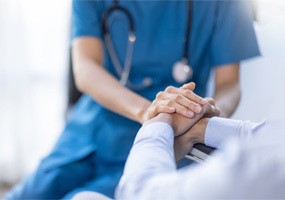 A Doctor holding patient's hands